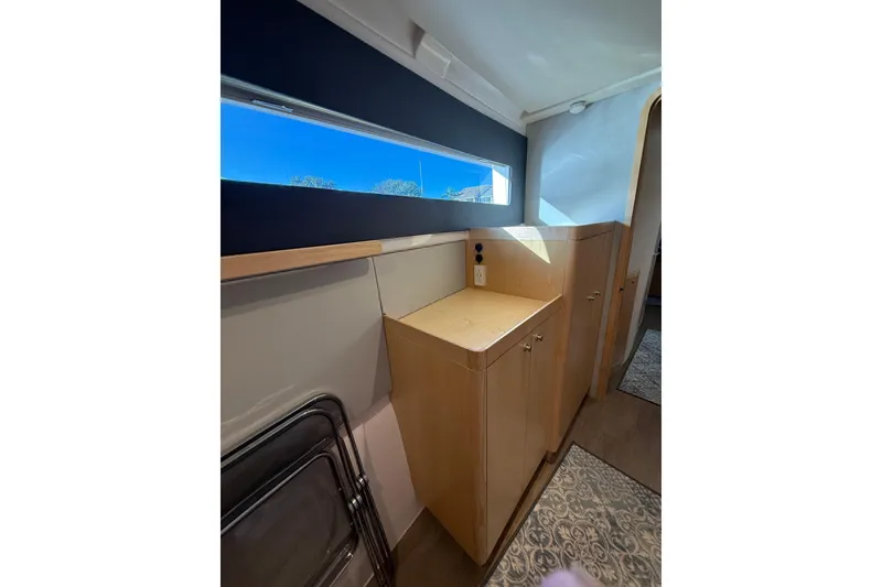 Slide: The Image of 2024 Seawind 1370 interior with wooden cabinetry and large window. - 44