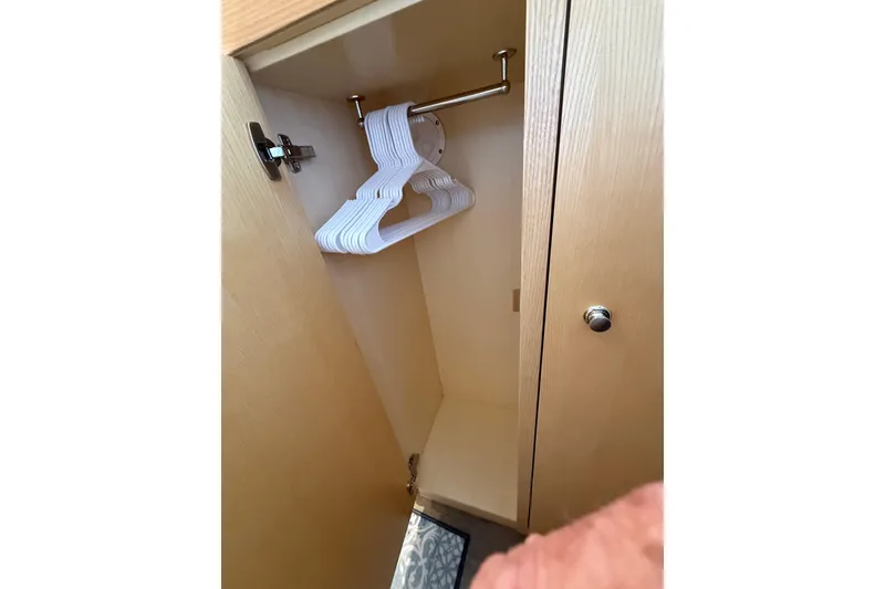 Slide: The Image of 2024 Seawind 1370 yacht closet with hangers, wooden interior. - 45