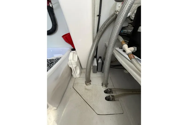 Slide: The Image of Engine compartment of 2024 Seawind 1370 with hoses and maintenance supplies. - 59