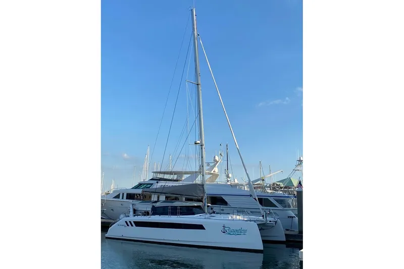 Slide: The Image of 2024 Seawind 1370 catamaran docked at marina under clear blue sky. - 6