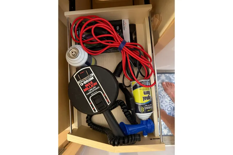 Slide: The Image of Drawer with boating equipment, including cables and a signal horn, on a 2024 Seawind 1370. - 63