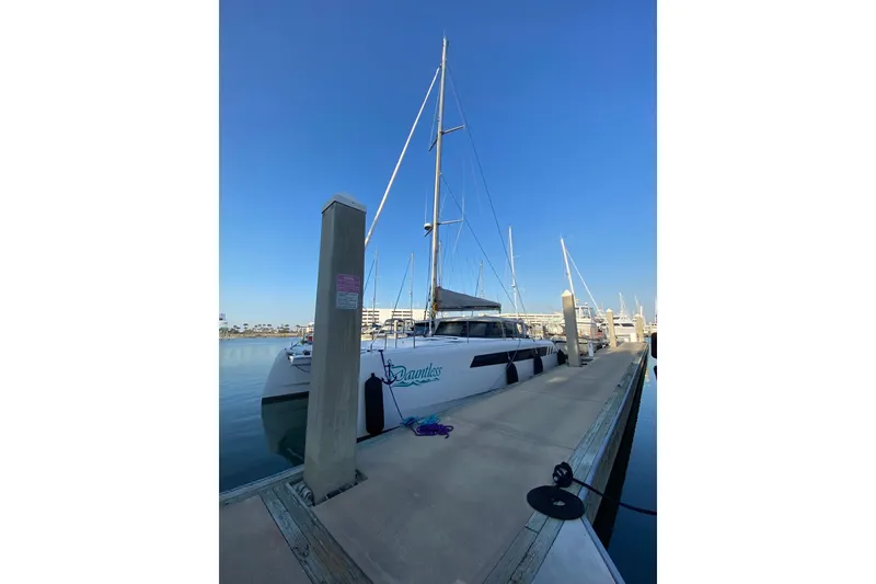 Slide: The Image of 2024 Seawind 1370 catamaran docked at marina under clear blue sky. - 7
