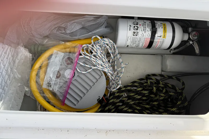 Slide: The Image of Storage compartment of 2024 Seawind 1370 with ropes, hose, and fire extinguisher. - 71