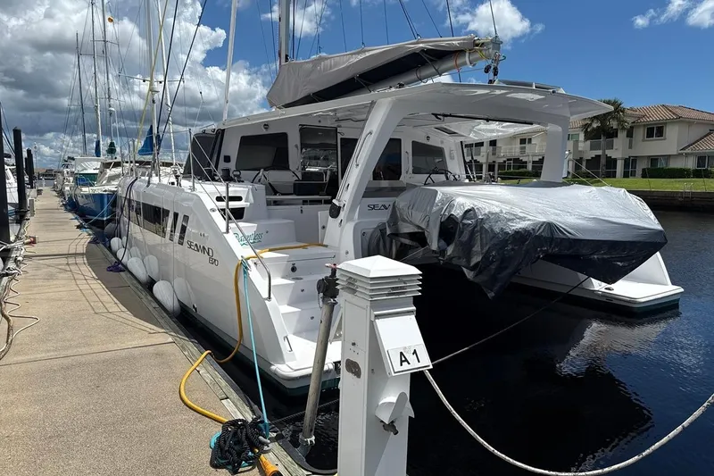 Slide: The Image of 2024 Seawind 1370 catamaran docked at marina under a partly cloudy sky. - 8