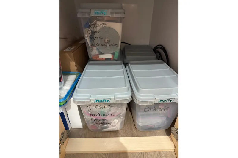 Slide: The Image of Storage bins labeled for rigging, electricals, and sealants on a Seawind 1370 yacht, 2024 model. - 95