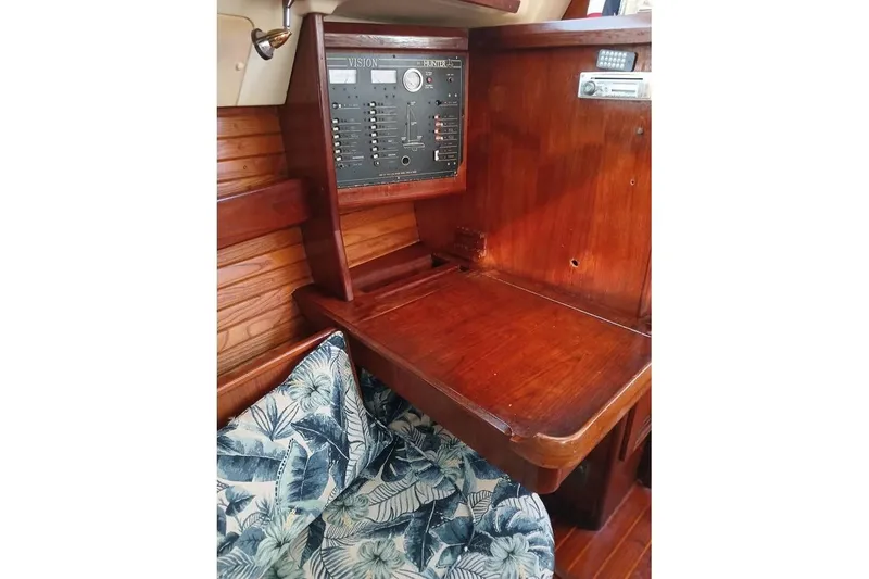 Slide: The Image of 1993 Hunter Vision 36 sailboat interior with wooden navigation station and floral cushion. - 11
