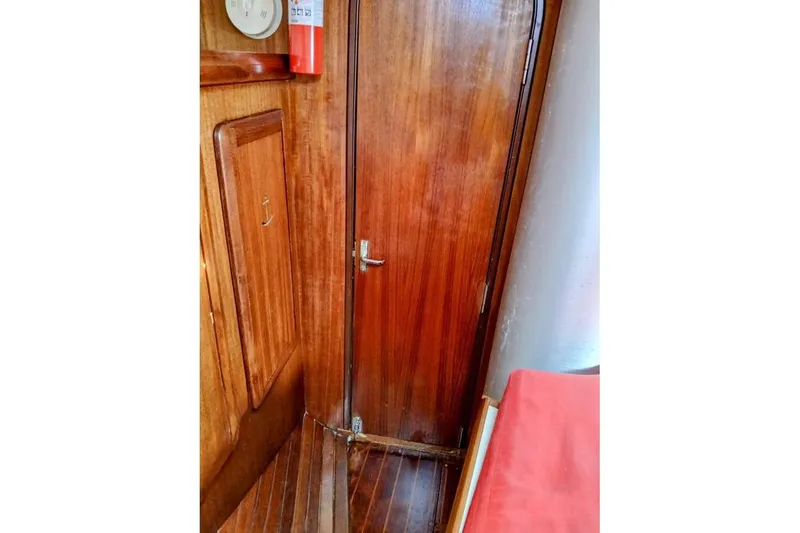 Slide: The Image of Interior of 1993 Hunter Vision 36 sailboat with wooden door and red cushion. - 13