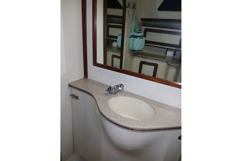 Slide: The Image of Bathroom sink area in a 1993 Hunter Vision 36 yacht, featuring a mirror and storage. - 21