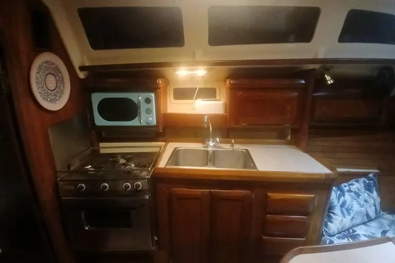 Slide: The Image of Interior of 1993 Hunter Vision 36 sailboat kitchen with stove, sink, and wooden cabinets. - 25