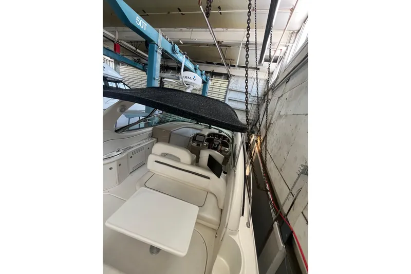 Slide: The Image of 2005 Sea Ray 360 Sundancer cockpit with seating and table, docked indoors. - 14