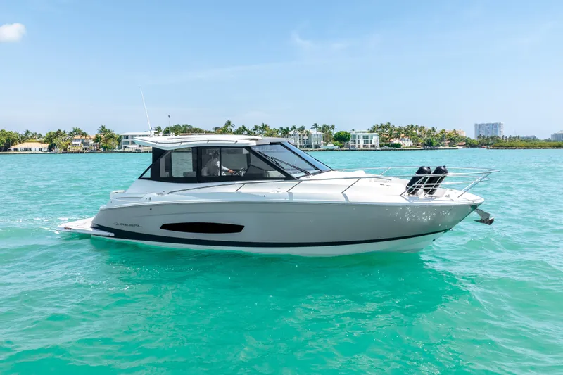 Slide: The Image of 2022 Regal 36 Grande Coupe cruising on turquoise water, clear sky background. - 1