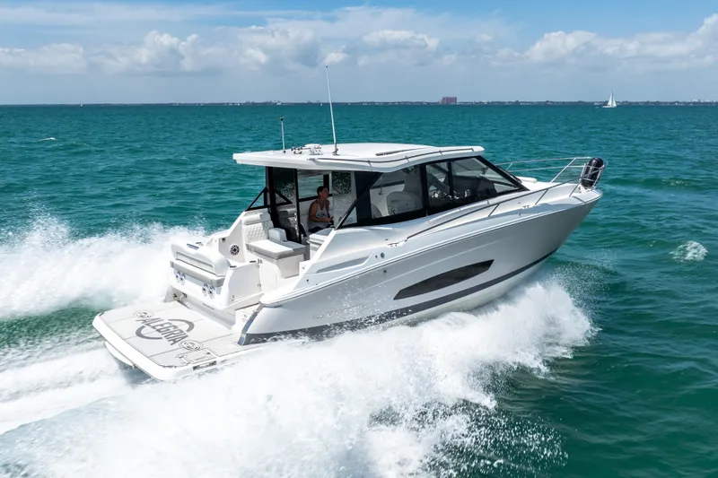 Slide: The Image of 2022 Regal 36 Grande Coupe cruising on open water, showcasing sleek design and performance. - 13
