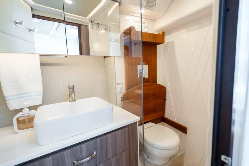 Slide: The Image of Modern bathroom in 2022 Regal 36 Grande Coupe yacht, featuring sleek sink and toilet. - 22