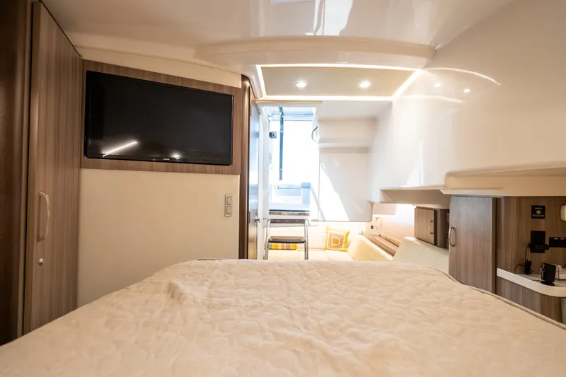 Slide: The Image of Interior of 2022 Regal 36 Grande Coupe yacht with bed, TV, and modern furnishings. - 32