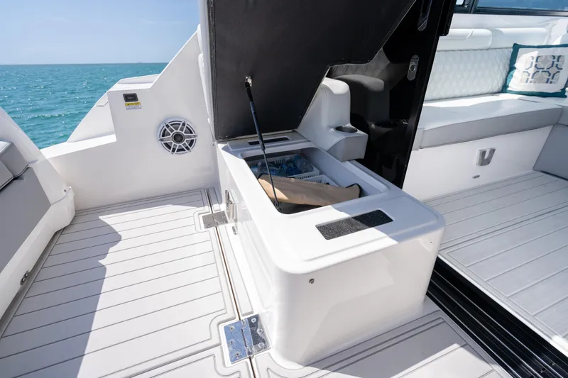 Slide: The Image of 2022 Regal 36 Grande Coupe boat interior with open storage compartment, ocean view. - 39