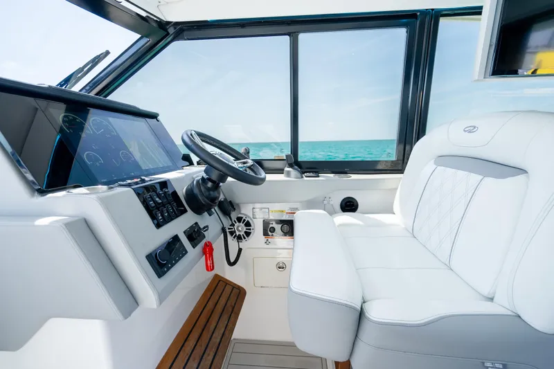 Slide: The Image of Helm of 2022 Regal 36 Grande Coupe with modern controls and luxurious seating. - 48