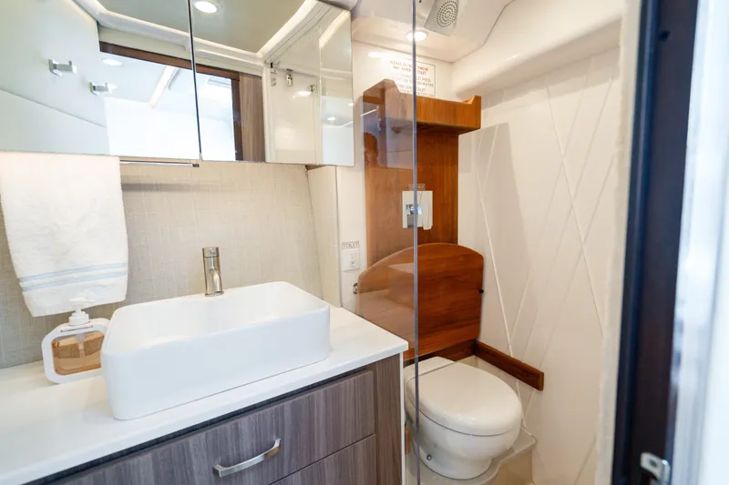 Slide: The Image of Modern bathroom in 2022 Regal 36 Grande Coupe yacht with sleek fixtures and wood accents. - 6