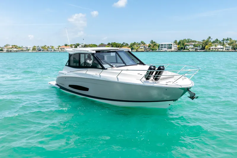 Slide: The Image of 2022 Regal 36 Grande Coupe cruising on turquoise waters under a clear blue sky. - 7