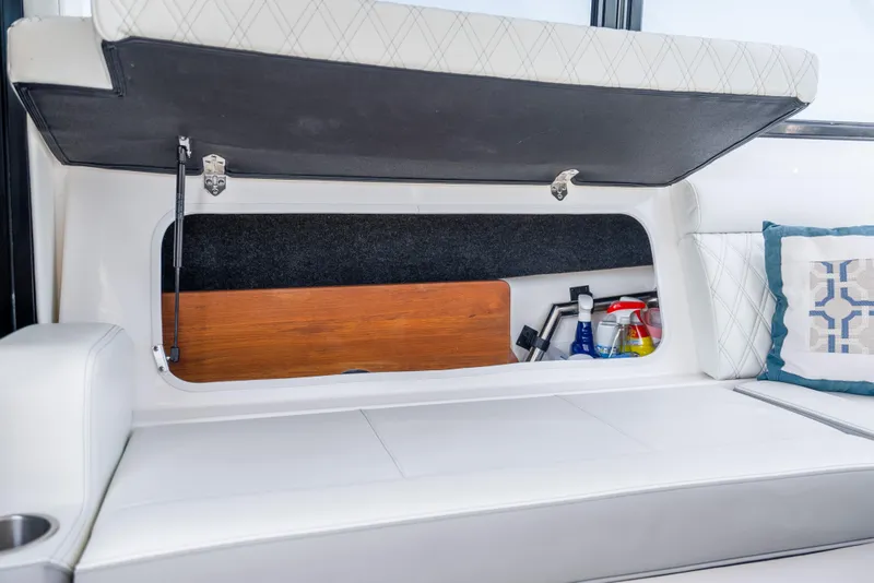 Slide: The Image of Storage compartment in 2022 Regal 36 Grande Coupe boat with cleaning supplies and cushion. - 73