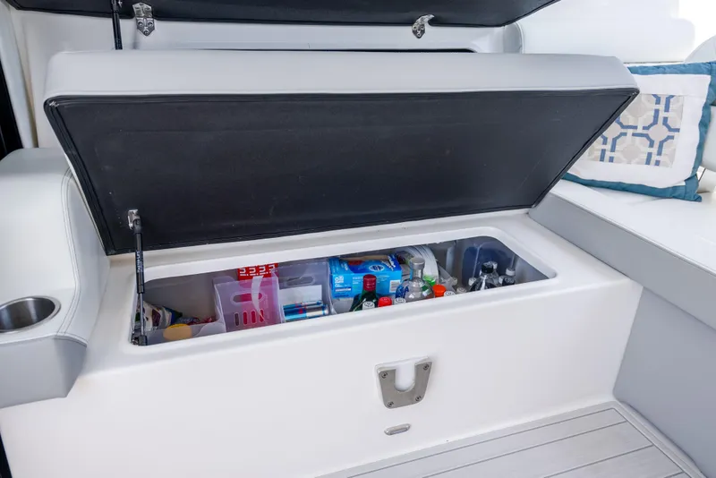 Slide: The Image of Open storage compartment on 2022 Regal 36 Grande Coupe, stocked with beverages and snacks. - 74