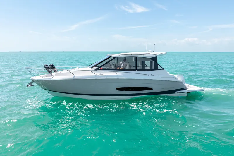Slide: The Image of 2022 Regal 36 Grande Coupe cruising on turquoise ocean waters under clear skies. - 9