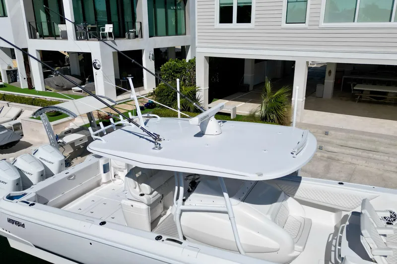 Slide: The Image of 2024 Intrepid 407 Nomad FE boat docked near modern waterfront home. - 10