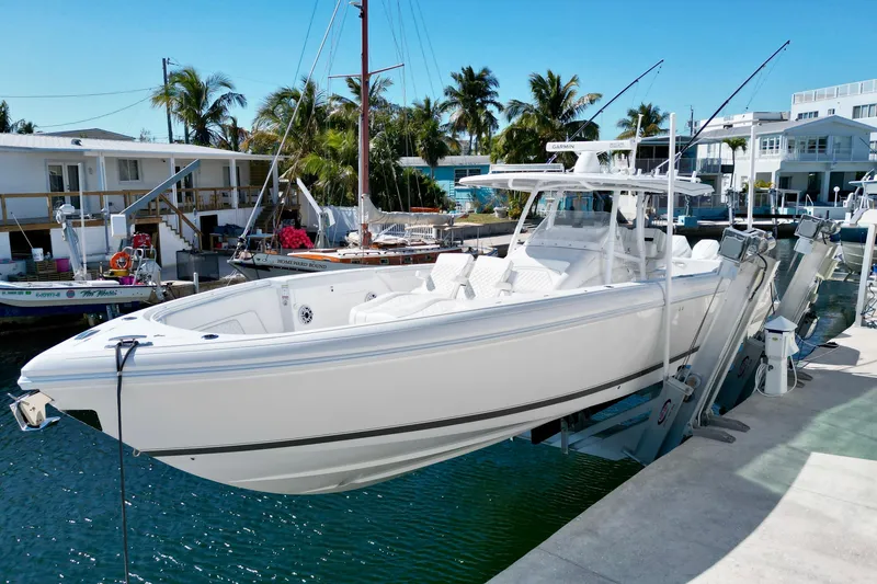 Slide: The Image of 2024 Intrepid 407 Nomad FE boat docked in a sunny marina setting. - 13