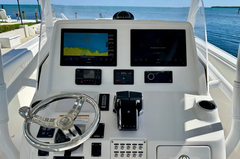 Slide: The Image of 2024 Intrepid 407 Nomad FE helm with navigation screens and steering wheel, overlooking the ocean. - 18