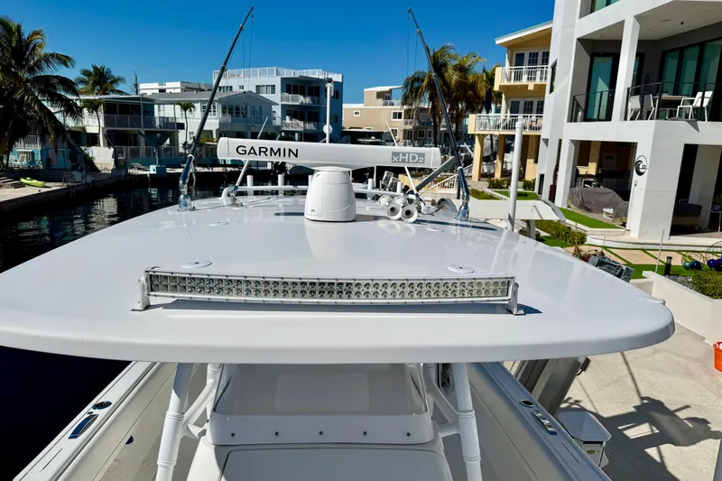 Slide: The Image of 2024 Intrepid 407 Nomad FE boat with Garmin radar, docked near modern waterfront homes. - 22