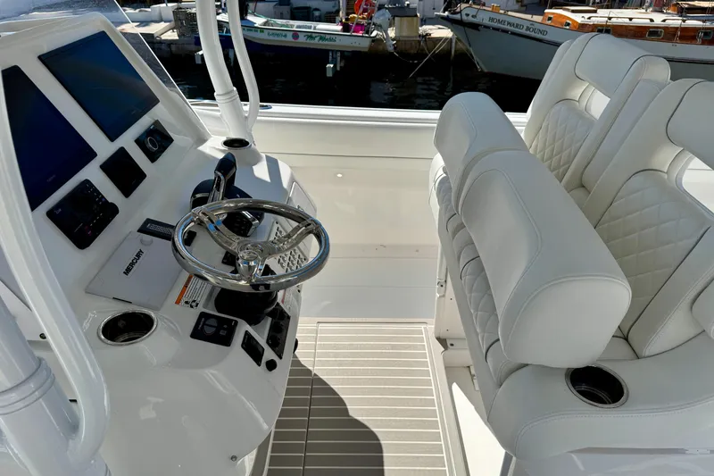 Slide: The Image of 2024 Intrepid 407 Nomad FE boat cockpit with white leather seats and modern controls. - 24