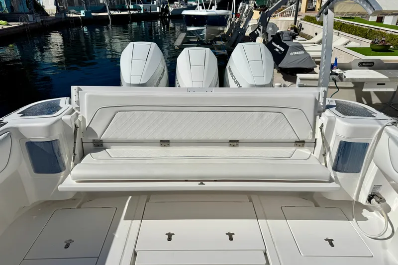 Slide: The Image of 2024 Intrepid 407 Nomad FE boat with triple Mercury engines at a marina. - 26