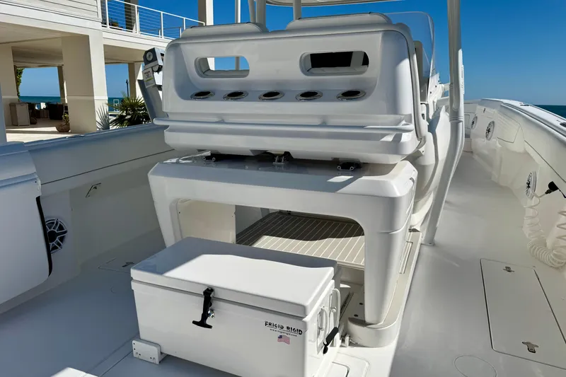 Slide: The Image of 2024 Intrepid 407 Nomad FE boat interior with seating and storage, ocean view in background. - 29