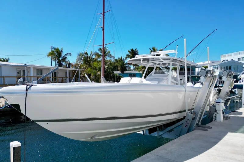 Slide: The Image of 2024 Intrepid 407 Nomad FE boat docked under clear blue sky. - 3