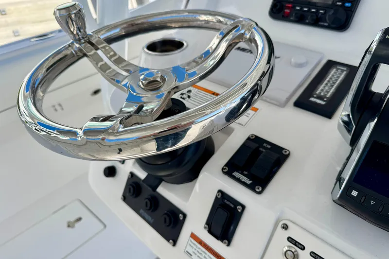 Slide: The Image of 2024 Intrepid 407 Nomad FE boat helm with polished steering wheel and controls. - 33