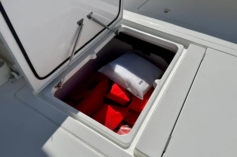 Slide: The Image of Open storage compartment on 2024 Intrepid 407 Nomad FE boat with life jackets inside. - 39