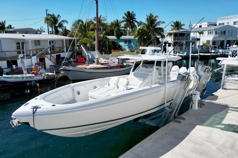 Slide: The Image of 2024 Intrepid 407 Nomad FE boat docked in a sunny marina setting. - 4