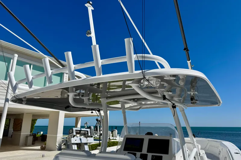 Slide: The Image of 2024 Intrepid 407 Nomad FE boat docked by a modern waterfront home. - 45
