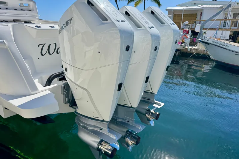 Slide: The Image of 2024 Intrepid 407 Nomad FE with triple Mercury outboard engines docked by the water. - 49