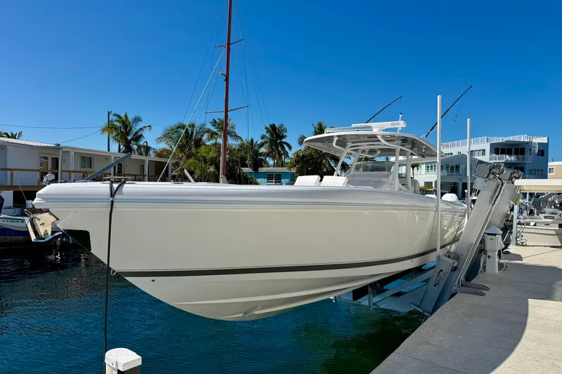 Slide: The Image of 2024 Intrepid 407 Nomad FE boat docked at marina under clear blue sky. - 50