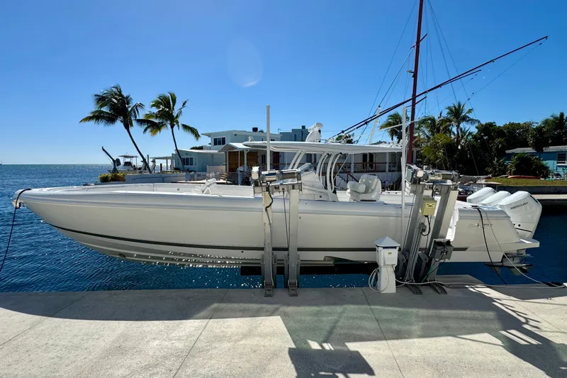 Slide: The Image of 2024 Intrepid 407 Nomad FE boat docked by waterfront with palm trees. - 52