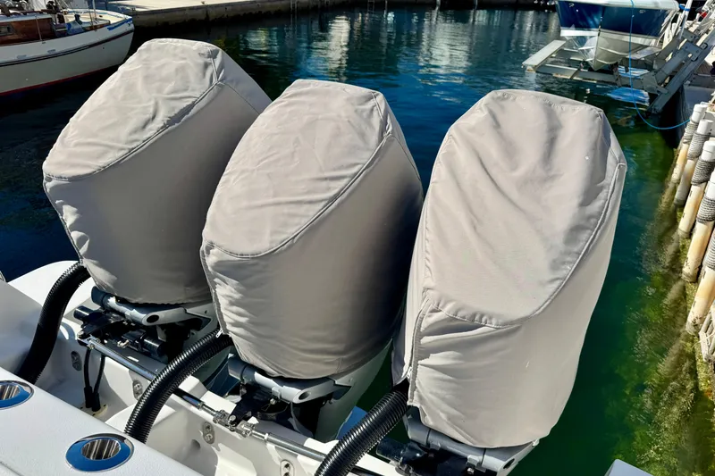 Slide: The Image of 2024 Intrepid 407 Nomad FE with covered outboard motors at a marina. - 54
