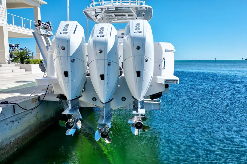 Slide: The Image of 2024 Intrepid 407 Nomad FE with triple outboard engines on clear blue water. - 7