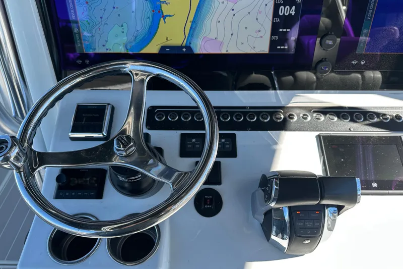 Slide: The Image of Control panel of a 2023 Freeman 42LR boat with navigation screens and steering wheel. - 16