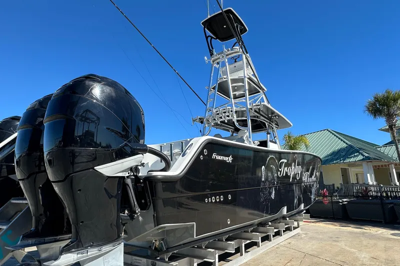 Slide: The Image of 2023 Freeman 42LR boat with dual engines, docked under clear blue sky. - 3