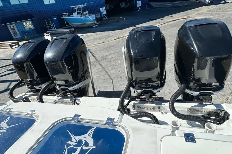 Slide: The Image of Four powerful outboard motors on a 2023 Freeman 42LR boat at a marina. - 4