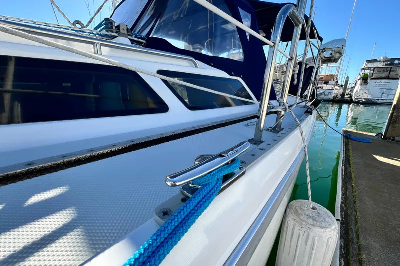 Slide: The Image of 1998 Catalina 36 MkII sailboat docked, featuring blue ropes and fender, with marina background. - 11