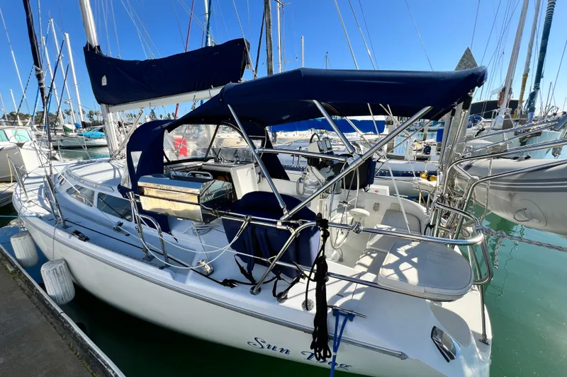 Slide: The Image of 1998 Catalina 36 MkII sailboat docked in marina, featuring blue canvas covers. - 14