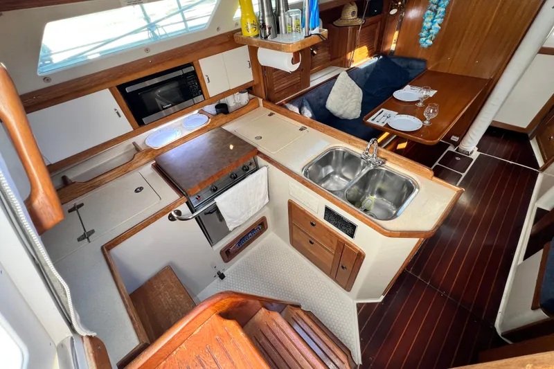 Slide: The Image of Interior of a 1998 Catalina 36 MkII sailboat featuring a cozy kitchen and dining area. - 34