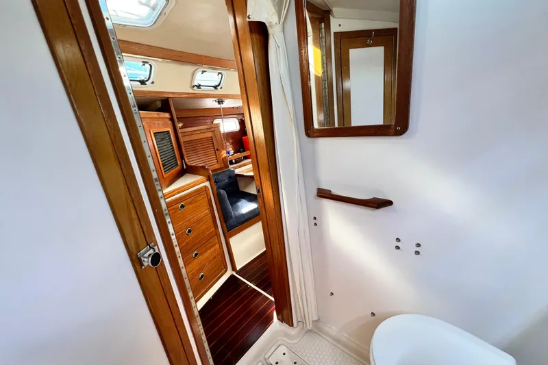 Slide: The Image of Interior of 1998 Catalina 36 MkII sailboat, featuring wooden cabinetry and cozy seating area. - 51