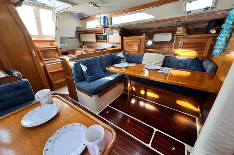 Slide: The Image of Interior of a 1998 Catalina 36 MkII sailboat with cozy dining area and wooden finishes. - 52